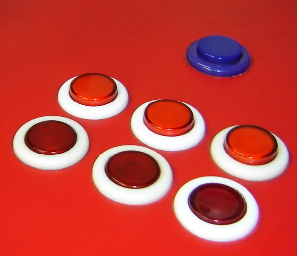 Red and blue concave arcade push buttons with white bezels on a red surface